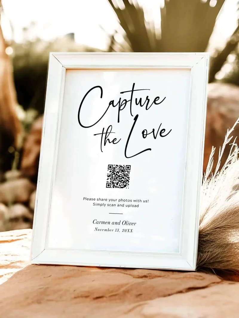 Ein gerahmtes QR-Code-Schild mit der Aufschrift „Capture the Love“ auf einer Hochzeit